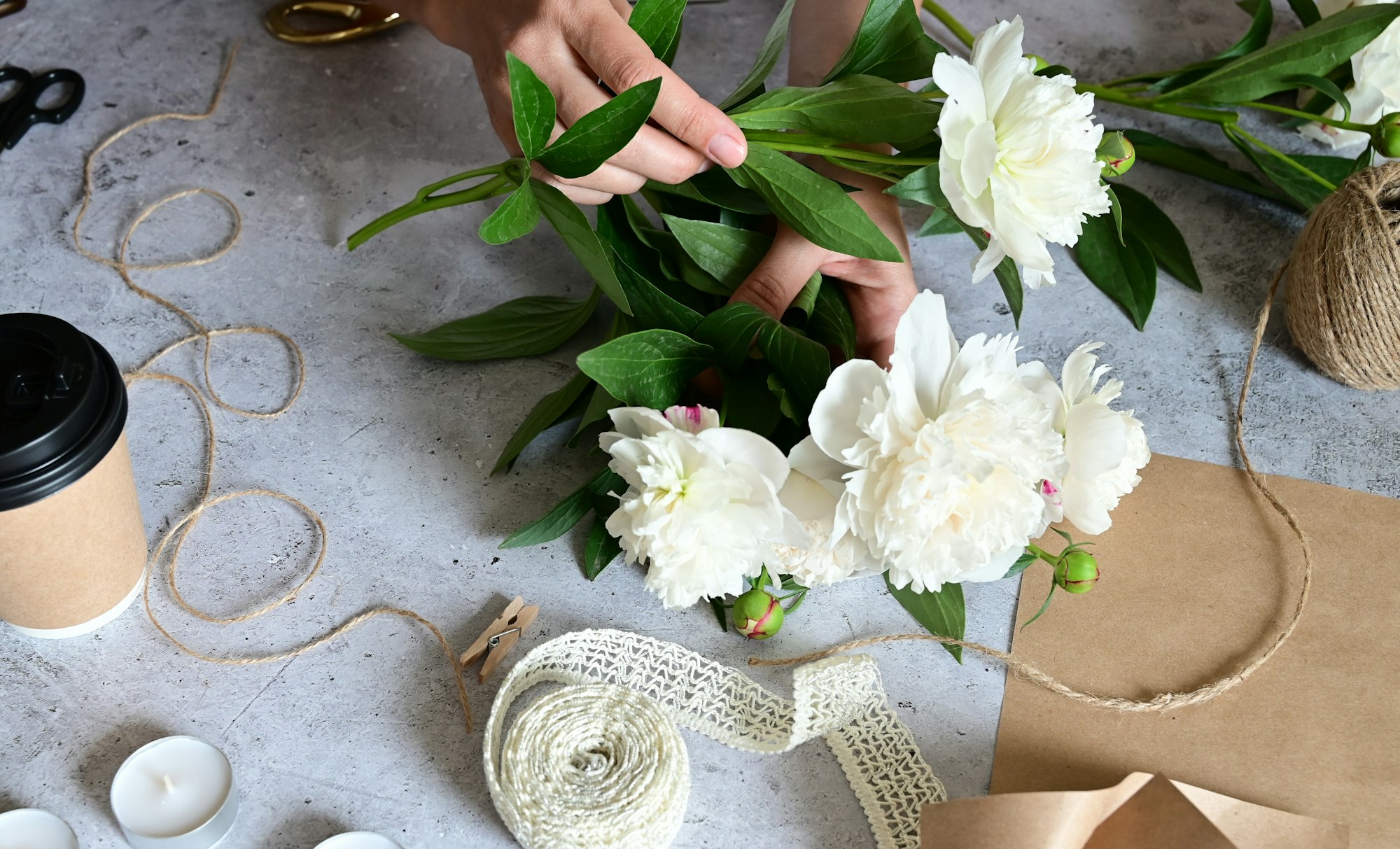 women's hands make a bouquet of peonies, pruning flowers